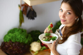 Young,Woman,Eating,Salad,And,Holding,A,Mixed,Salad